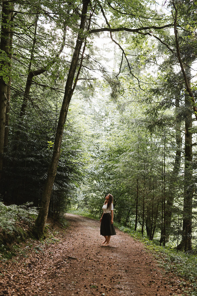 Frauenportrait im Wald Frau geht auf Waldweg